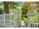 View of white picket fence leading to walkway with garden and the house number 400 on a white post at 400 Bowling Creek Rd, Chapel Hill, NC 27514