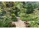 Lush garden path with stone pavers, manicured plants, and charming stone accents at 400 Bowling Creek Rd, Chapel Hill, NC 27514