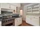 Well-appointed kitchen featuring stainless steel stove, tile backsplash, and white cabinets with granite counters at 400 Bowling Creek Rd, Chapel Hill, NC 27514