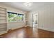 Bright living room featuring hardwood floors, built-in bookshelves, and a large window with a view of the trees at 400 Bowling Creek Rd, Chapel Hill, NC 27514