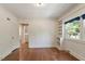 Living room with hardwood floors and white walls showcasing a window offering natural light and access to the exterior at 400 Bowling Creek Rd, Chapel Hill, NC 27514