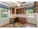A home office boasts hardwood floors, built-in shelving, and a custom wood desk bathed in natural light at 400 Bowling Creek Rd, Chapel Hill, NC 27514