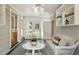 Inviting sunroom featuring white wicker furniture, and multiple windows with a view of the yard at 400 Bowling Creek Rd, Chapel Hill, NC 27514