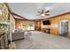 Inviting living room with wood paneling, stone fireplace, and large windows offering plenty of natural light at 409 W Holding St, Smithfield, NC 27577