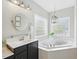 Serene bathroom featuring a soaking tub with windows, stylish vanity, and a clean, modern aesthetic at 415 Waverly Hills Dr, Cary, NC 27519