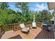 Outdoor deck showcasing patio furniture, a grill, and surrounded by lush greenery and mature trees at 415 Waverly Hills Dr, Cary, NC 27519