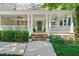 Inviting front porch with white columns and railings, planters, and a teal front door at 415 Waverly Hills Dr, Cary, NC 27519
