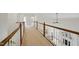 Bright hallway with wooden railings overlooks the living room with a fireplace at 415 Waverly Hills Dr, Cary, NC 27519