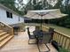 A cozy back deck with outdoor dining set, grill and lush wooded views creates a relaxing atmosphere at 420 Spring Ln, Henderson, NC 27537