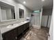Bathroom with double sinks, wood-look floors, neutral walls and a large shower at 420 Spring Ln, Henderson, NC 27537