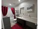 Bathroom features a white sink with dark brown cabinets, a toilet, and a tub with dark red curtains at 420 Spring Ln, Henderson, NC 27537