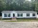 Charming manufactured home featuring white siding, black shutters and a nice gravel driveway at 420 Spring Ln, Henderson, NC 27537