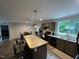 Modern kitchen and dining area featuring wood cabinets, black appliances and a window view at 420 Spring Ln, Henderson, NC 27537