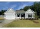 Charming single-story home featuring a two-car garage, stone accents and a well-manicured lawn at 445 Olivia Crossing Ct # 22, Four Oaks, NC 27524