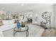 Open-concept living area flows into kitchen, featuring modern furnishings and a large clock at 445 Olivia Crossing Ct # 22, Four Oaks, NC 27524