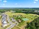 Aerial view of a community featuring a golf course, tennis courts, and a pool at 46 Waterfall Pointe, Chapel Hill, NC 27517