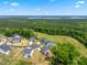 A high angle, birds eye view of new construction homes in a suburban neighborhood surrounded by forest and green space at 46 Waterfall Pointe, Chapel Hill, NC 27517