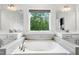 Bathroom featuring a soaking tub beneath a window and double sink vanities each with a large mirror above at 46 Waterfall Pointe, Chapel Hill, NC 27517