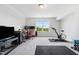 Bonus room setup for home office with desk and monitors; nearby a home gym with an exercise bike and weights at 46 Waterfall Pointe, Chapel Hill, NC 27517