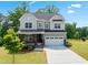 Charming two-story home featuring stone accents, a covered porch, a well-manicured lawn, and an attached two-car garage at 46 Waterfall Pointe, Chapel Hill, NC 27517