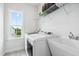 Well-lit laundry room featuring a large sink, washer, dryer, window, and shelving for organization at 46 Waterfall Pointe, Chapel Hill, NC 27517