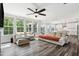 Bright living room featuring a ceiling fan, hardwood floors, large windows, and views of the kitchen and backyard at 46 Waterfall Pointe, Chapel Hill, NC 27517