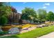 Beautiful community water feature with waterfall, mature trees, and lush landscaping at 46 Waterfall Pointe, Chapel Hill, NC 27517