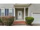 Inviting front entry showcasing a white front door, brick steps, and well-maintained landscaping at 468 Hay River St, Garner, NC 27529