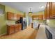 Well-lit kitchen featuring wood cabinets, stainless steel appliances, and wood flooring at 468 Hay River St, Garner, NC 27529