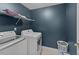 Functional laundry room with a washer, dryer, and wire rack shelving at 468 Hay River St, Garner, NC 27529