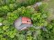 Aerial view of a home with a red roof surrounded by a dense canopy of lush trees at 4701 Brock Dr, Hurdle Mills, NC 27541