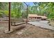 A backyard featuring a cozy swing, stone patio, dining table, and a charming home with a metal roof at 4701 Brock Dr, Hurdle Mills, NC 27541