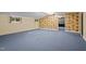 Large finished basement area with blue carpet and brick accent walls at 4701 Brock Dr, Hurdle Mills, NC 27541