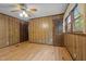 Empty bedroom boasts hardwood floors, wood paneling, and a ceiling fan at 4701 Brock Dr, Hurdle Mills, NC 27541