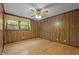 Empty bedroom boasts a ceiling fan, hardwood floors, and wood paneling at 4701 Brock Dr, Hurdle Mills, NC 27541