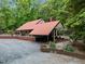 Exterior view of house with a metal roof surrounded by trees and flowers at 4701 Brock Dr, Hurdle Mills, NC 27541