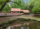 View of exterior of home with pond and surrounding trees and foliage at 4701 Brock Dr, Hurdle Mills, NC 27541