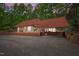 Wide angle view of house with metal roof and brick foundation in wooded area at 4701 Brock Dr, Hurdle Mills, NC 27541