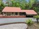 View of house with metal roof and brick foundation in wooded area at 4701 Brock Dr, Hurdle Mills, NC 27541