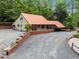 Exterior shot of house with large parking area, trees, and a metal roof at 4701 Brock Dr, Hurdle Mills, NC 27541