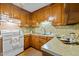 A kitchen showcasing wooden cabinets, stainless steel sink, and white electric stove at 4701 Brock Dr, Hurdle Mills, NC 27541