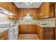 Traditional kitchen featuring wood cabinets, stainless steel sink, and a white range at 4701 Brock Dr, Hurdle Mills, NC 27541