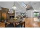 Spacious living area featuring a brick fireplace, hardwood floors, and vaulted ceilings at 4701 Brock Dr, Hurdle Mills, NC 27541