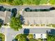 A close aerial view showcases a group of charming townhomes, lush green trees, and convenient parking at 4703 Kings Garden Rd, Raleigh, NC 27612