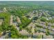 An expansive aerial view shows a residential neighborhood filled with homes and lush greenery surrounding the area at 4703 Kings Garden Rd, Raleigh, NC 27612