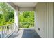Serene balcony with tiled flooring, a white railing, and surrounded by lush greenery for a peaceful outdoor retreat at 4703 Kings Garden Rd, Raleigh, NC 27612