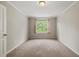 Cozy bedroom with neutral carpet and a window with light pink curtains at 4703 Kings Garden Rd, Raleigh, NC 27612