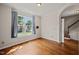 Comfortable, light-filled empty room with hardwood flooring, large window with curtains, and neutral wall paint at 4703 Kings Garden Rd, Raleigh, NC 27612