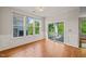 Dining area with hardwood floors, large windows, sliding door to balcony, and elegant trim for refined living at 4703 Kings Garden Rd, Raleigh, NC 27612