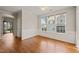 Bright dining room featuring large windows, paneled walls, and hardwood flooring at 4703 Kings Garden Rd, Raleigh, NC 27612